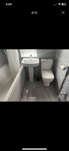 a small bathroom with a toilet and a sink at Numan’s guest house in Coundon