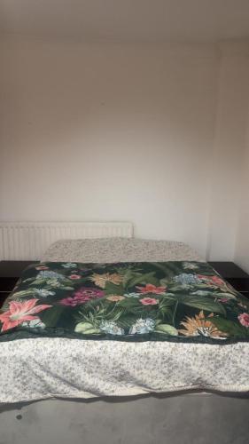 Una cama con colcha floral encima. en Numan’s guest house, en Coundon