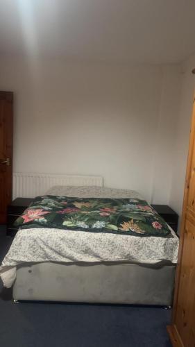 a bed with a quilt on it in a bedroom at Numan’s guest house in Coundon