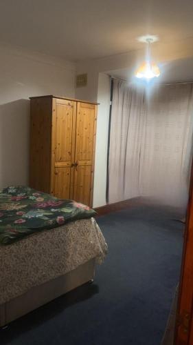 1 dormitorio con 1 cama, vestidor y ventana en Numan’s guest house, en Coundon