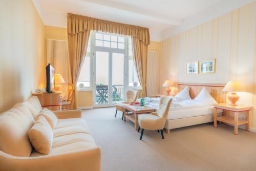 a hotel room with a couch and a table at Strandhotel Möwe in Bansin