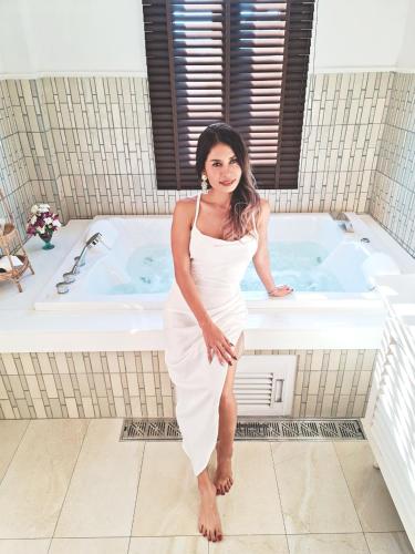 a woman in a white dress standing in front of a tub at Buri Sriping Riverside Resort & Spa in Chiang Mai
