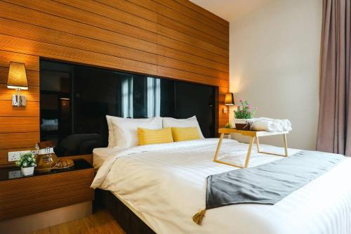 1 dormitorio con 1 cama grande y cabecero de madera en Kl Sentral 2bedroom Muji Family Suite #Netflix 8pax, en Kuala Lumpur