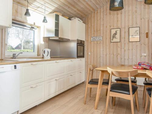 une cuisine avec des placards blancs et une table en bois dans l'établissement 6 person holiday home in Tarm, à Tarm