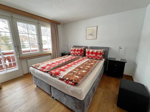ein Schlafzimmer mit einem großen Bett mit roten Kissen in der Unterkunft Haus Vira in Zermatt