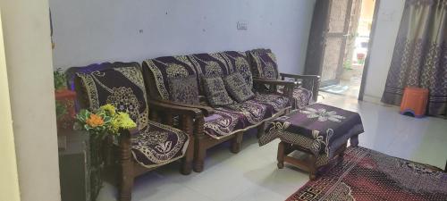 a living room with a couch and chairs and a table at chirayu home stay in Ujjain