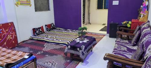 a room with purple walls and a table and chairs at chirayu home stay in Ujjain