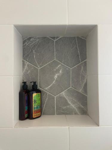 a shelf with two bottles ofodorizers in a bathroom at בין הר ובין ים in Ovnat