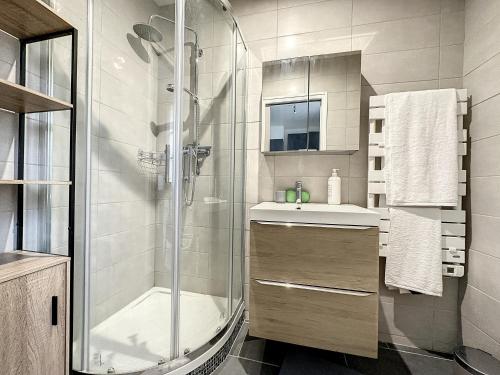 uma casa de banho com um chuveiro e um lavatório. em appartement au 1er étage avec accès indépendant em Saint-Denis