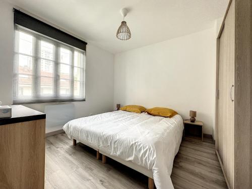 um quarto branco com uma cama e uma janela em appartement au 1er étage avec accès indépendant em Saint-Denis