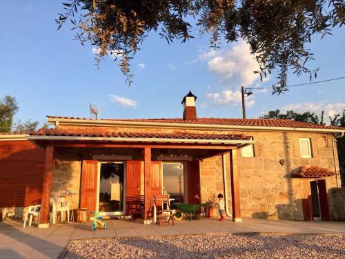 a small stone house with a patio in front of it at Casa da Fonte in Novelães