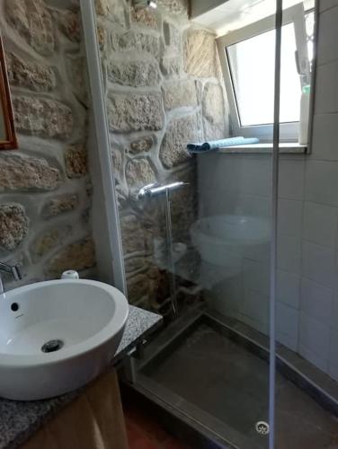 a bathroom with a sink and a glass shower at Casa da Fonte in Novelães