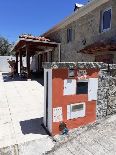 a refrigerator outside of a building next to a building at Casa da Fonte in Novelães