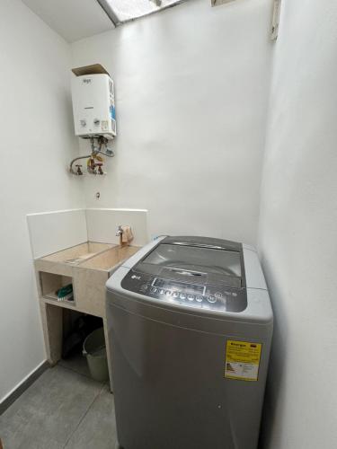 - Lavadora en una habitación con lavabo en Apartamentos Area Medica Imbanaco, en Cali
