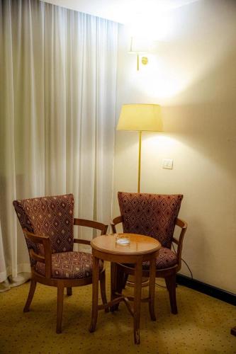 paradise hotel في القاهرة: غرفة بها كرسيين وطاولة ومصباح