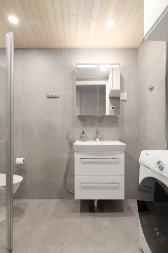 a bathroom with a white sink and a shower at Sea View Design Studio near metro in Espoo in Espoo