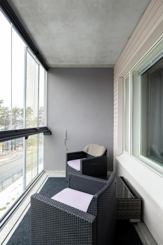 a room with two chairs and a table and windows at Sea View Design Studio near metro in Espoo in Espoo