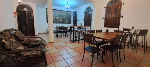 a dining room with chairs and a table and tables at Pousada Economic Pitangui in Pitangui