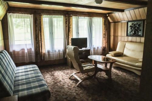 a living room with a couch and a table at Ośrodek Wypoczynkowy U Dobrego Ducha in Niedzica Zamek