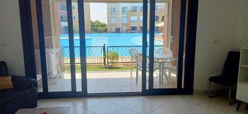 エル・アラメインにあるMarassi Verdi Pool View North Coastのプールを望むガラスのスライドドアが備わる客室です。