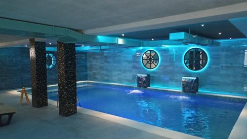 una piscina con luces azules en un edificio en White pearl, en Veliko Gradiste