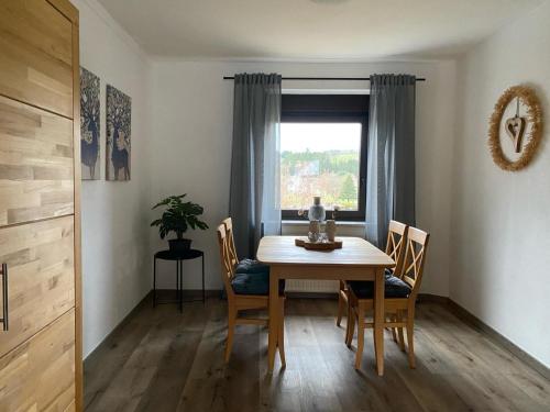 a dining room with a table and chairs and a window at Ferienwohnung Burgberg in Stadtkyll