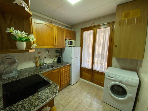 uma cozinha com um lavatório e uma máquina de lavar roupa em Sant Jordi 2 em Tremp