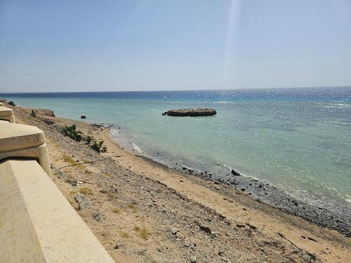 a beach with a rock in the water at فندق سي قل - Sea gull Hotel in Umm Lujj