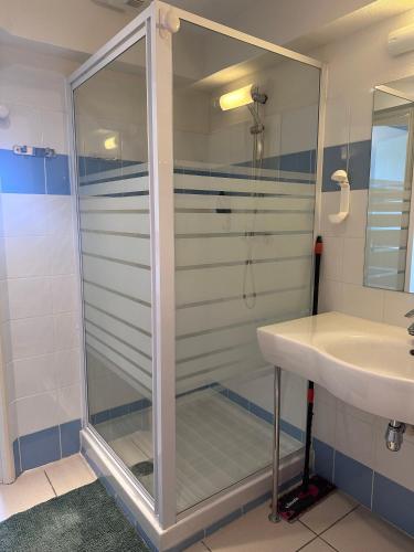 une douche en verre dans une salle de bain avec un lavabo dans l'établissement Charmant studio le clos d'Aix parking privé gratuit et piscine, à Aix-en-Provence