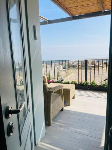 a door to a balcony with a view of the ocean at בין הר ובין ים in Ovnat