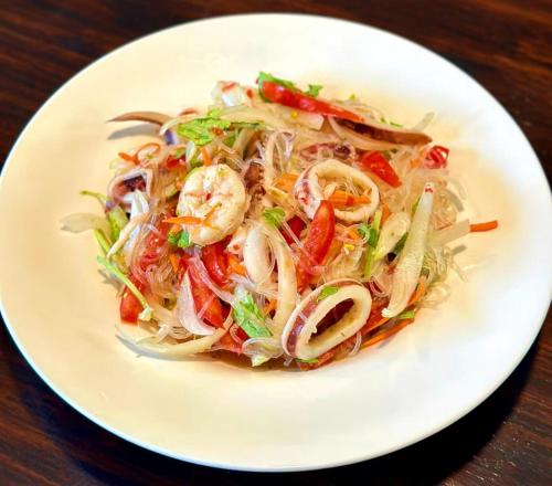a white plate of food with shrimp and vegetables at มนต์เมืองเชียงใหม่ รีสอร์ต Monmuang Chiangmai Resort in Hang Dong