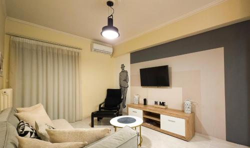 - un salon avec un canapé et une télévision murale dans l'établissement Kostas Home by Bill Apartments, à Patras