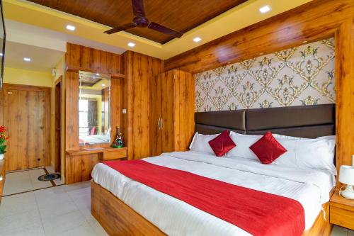 a bedroom with a large bed with red pillows at Hotel Ashray Near Temple & Beach By Morservices in Puri