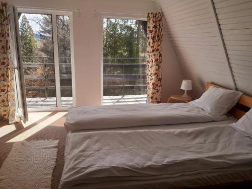 a bedroom with a bed and a large window at Pine tree cottage in Zlatibor