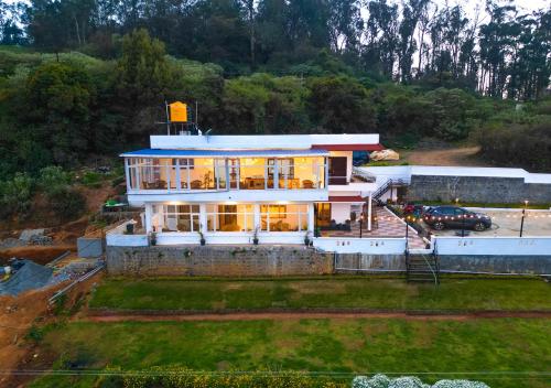 an aerial view of a large house with a car at Silent Retreat Ooty Farm Resort by VOYE HOMES in Ooty