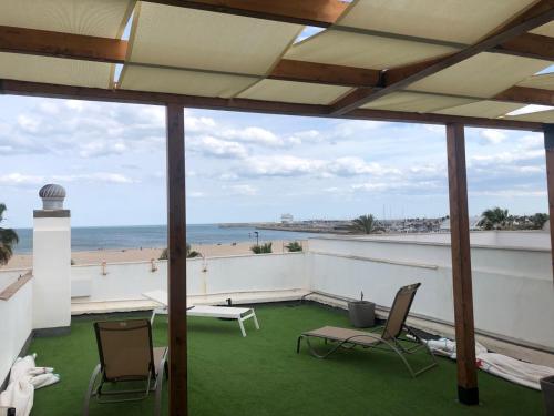 a balcony with chairs and a view of the beach at El Globo in Valencia