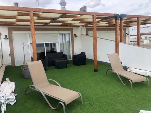 a patio with two chairs and a table on grass at El Globo in Valencia