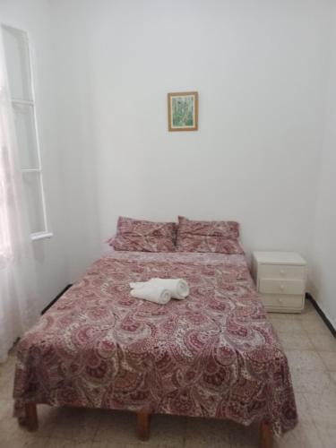 uma cama com um objecto branco em cima em Maison pied dans l'eau -Bainem Alger em Baïnem Falaise
