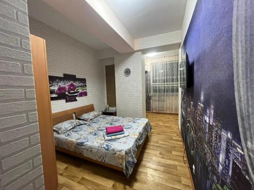 - une chambre avec un lit et un mur dans l'établissement Richmond, à Almaty