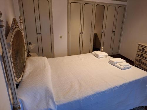 a bedroom with a bed with two towels on it at Casa das Floreiras - City Center Apartment in Horta