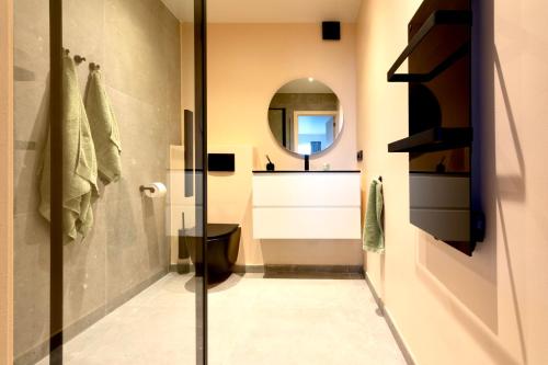 a bathroom with a toilet and a mirror at Studio By Aimee in Ostend