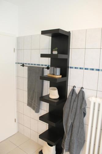 a black shelf in a bathroom with towels at Apartment mit 2 Betten in Flughafennähe in Paderborn