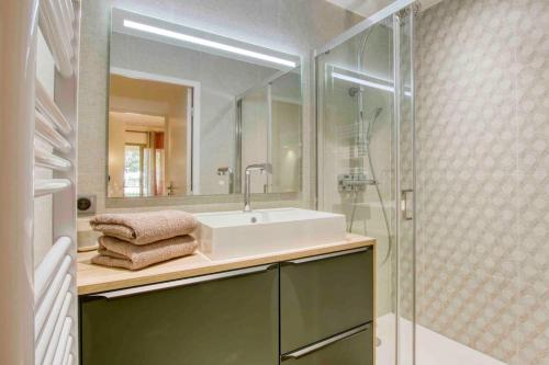 La salle de bains est pourvue d'un lavabo et d'une douche en verre. dans l'établissement Appartement piscine tennis accès privé plage Joïa, à Sanary-sur-Mer