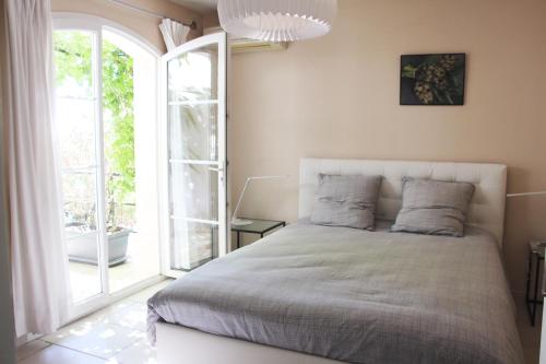 une chambre avec un lit et une grande fenêtre dans l'établissement Panoramix, à Villevieille