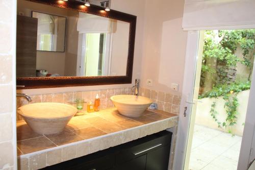 une salle de bain avec deux lavabos et un miroir dans l'établissement Panoramix, à Villevieille