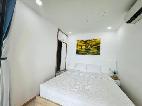 a bedroom with a white bed and a window at NHA TRANG COMFORTZONE APARTMENT in Nha Trang