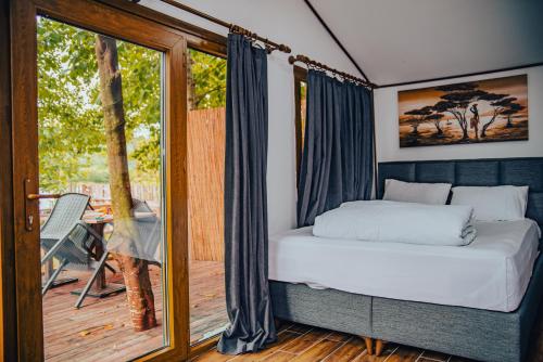 Danzi camping tiny house في ريزي: غرفة نوم مع سرير وبلكونة مع طاولة