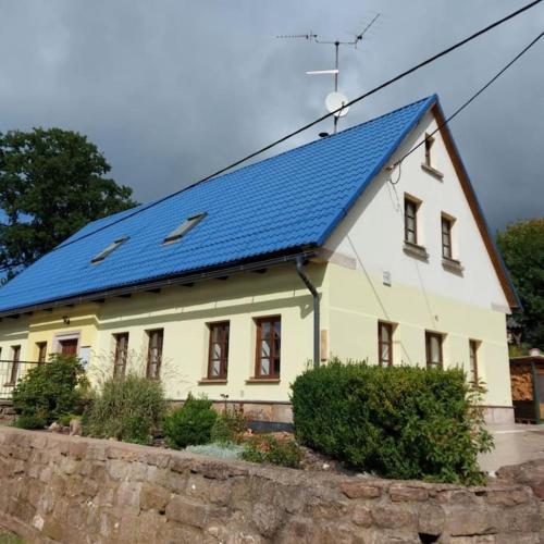 una gran casa blanca con techo azul en Apartmán U Davida, en Chvaleč