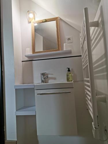 une salle de bain avec un lavabo et un miroir dans l'établissement Chopin, à Les Haies
