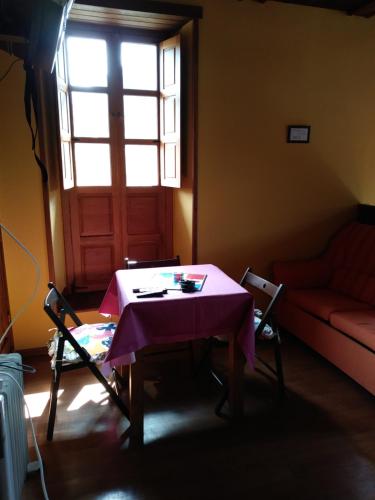 a room with a table and a couch and a window at OSO3 in Pola de Somiedo